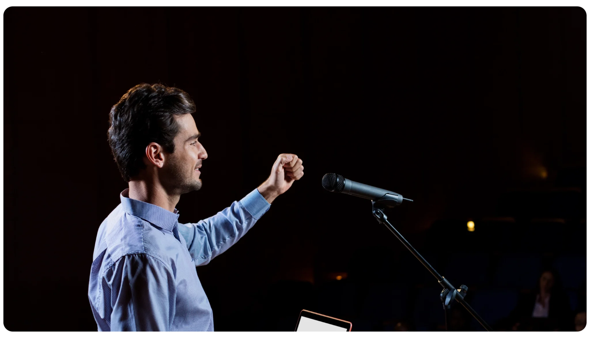 Speaker presenting on stage at an in-person event